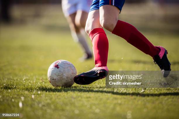 unrecognizable female soccer player with a ball during a match on playing field. - pointed foot stock pictures, royalty-free photos & images