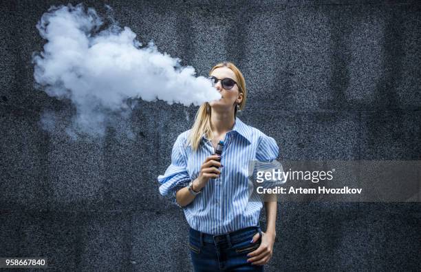 young female smoking electronic cigarette - electronic cigarette stock pictures, royalty-free photos & images