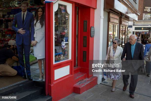 Life-size standee of Prince Harry and Meghan Markle with souvenirs and merchandise on sale in a the doorway of a tourist trinket window as the royal...