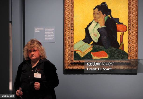 Woman stands adjacent to an oil painting by acclaimed Dutch artist Vincent Van Gogh entitled "Madame Joseph-Michel Ginoux with Books" in an...