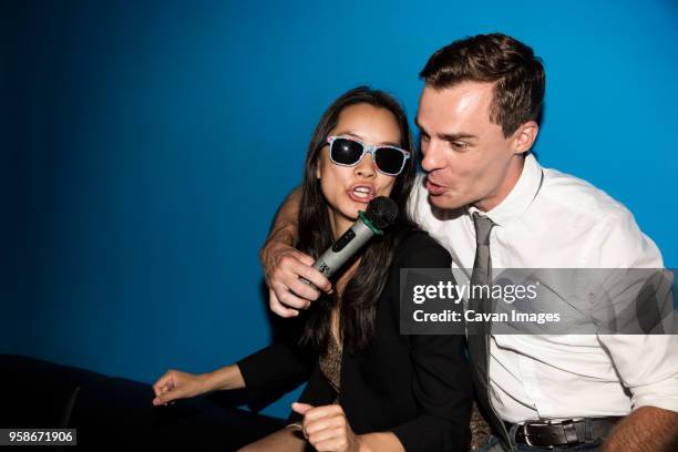 happy couple singing karaoke in nightclub - karaoke stock pictures, royalty-free photos & images