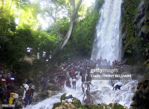 Haitians stand under the waterfall in Saut d'Eau, 72km north of Port-au-Prince, during the annual pilgrimage 16 July 2006. Each year, thousands of...