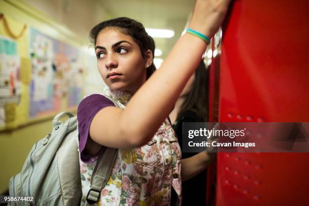 woman looking away while standing in locker room - locker room ストックフォトと画像