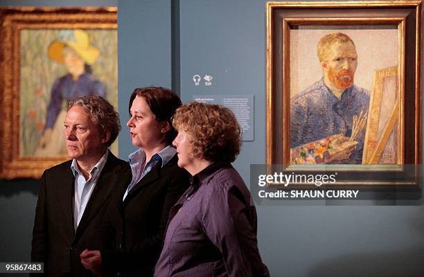 Members of the Van Gogh family pose for photographs alongside a self portrait of Dutch artist Vincent Van Gogh at the opening of an exhibition of the...