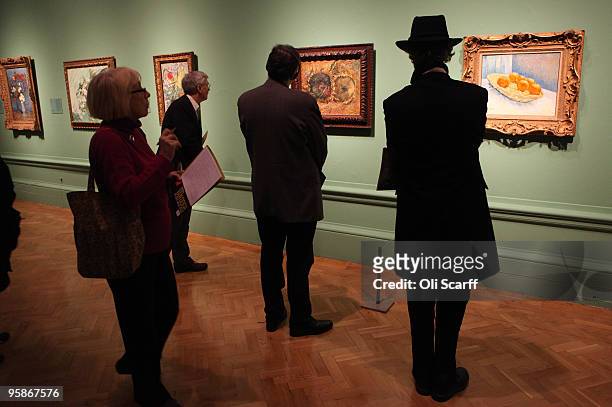 Members of the public admire paintings by the acclaimed Dutch artist Vincent Van Gogh at the press viewing of an exhibition of his work held at the...