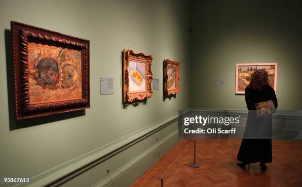 Woman views oil paintings by the acclaimed Dutch artist Vincent Van Gogh at the press viewing of an exhibition of his work held at the Royal Academy...