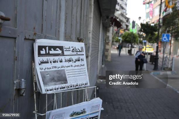 Daily newspapers are seen in front of closed shops in Ramallah, during a general strike, to mourn Palestinians who were killed by Israeli army...