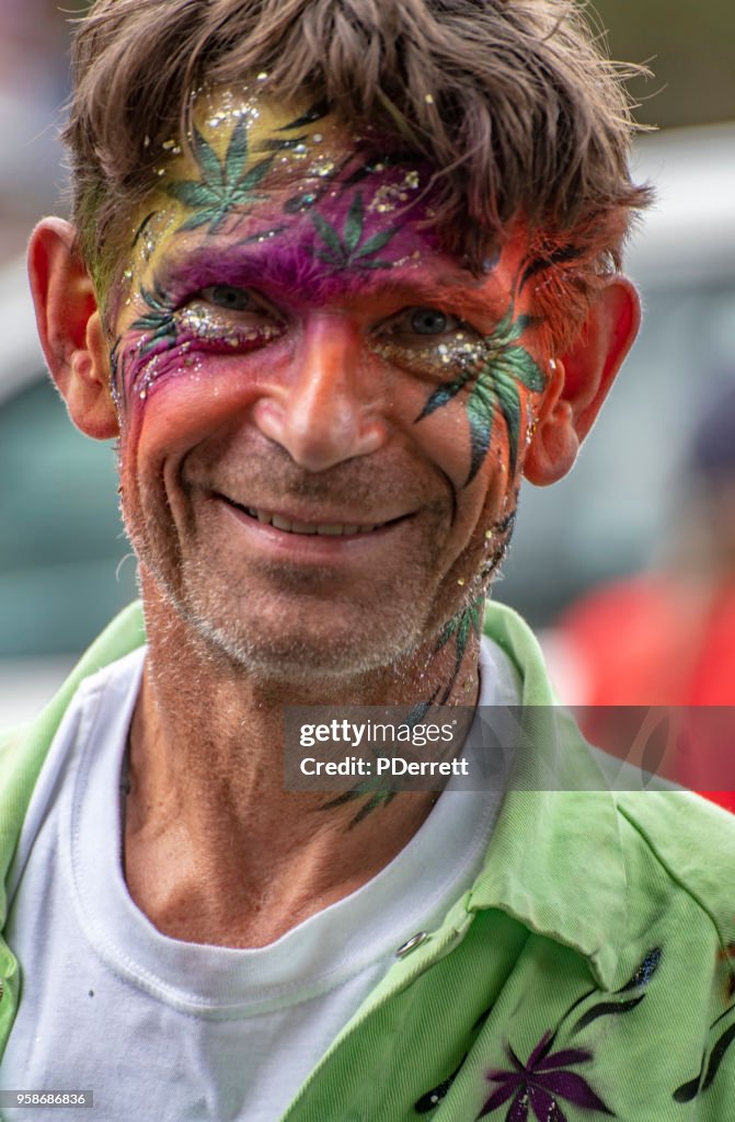 Mann mit Gesicht im Festival-Motiv gemalt.