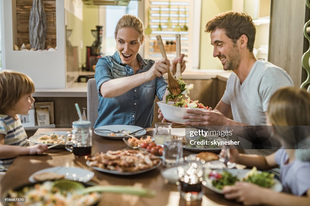 Jonge gelukkige familie genieten in hun lunchpauze op de eettafel.