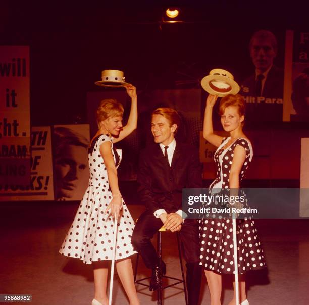 British singer Adam Faith poses with two women in the 1960's.