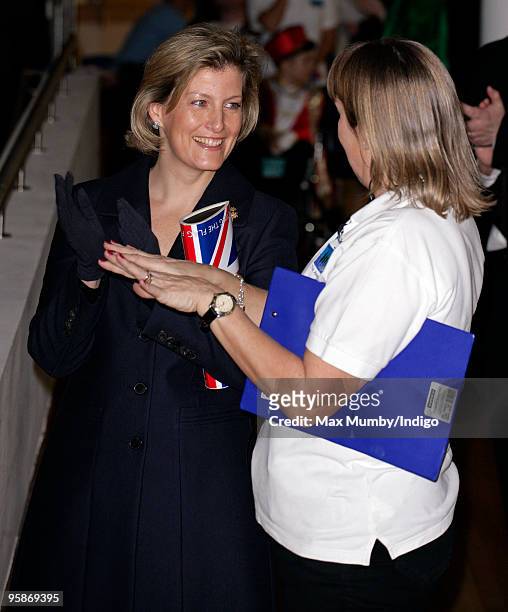Sophie, Countess of Wessex carries a 'Papa Razzi' Union Jack Flag clutch style handbag, emblazoned with the slogans "Britannia Rules" and "Flying The...