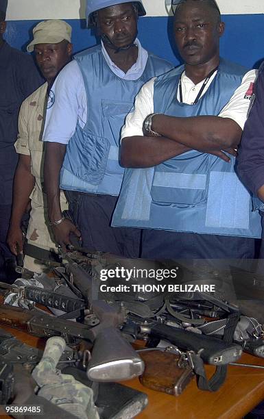 African Police from the MINUSTAH stand during a press conference 11 April 2005, behind arms and munitions that were taken by Haitian Police and...