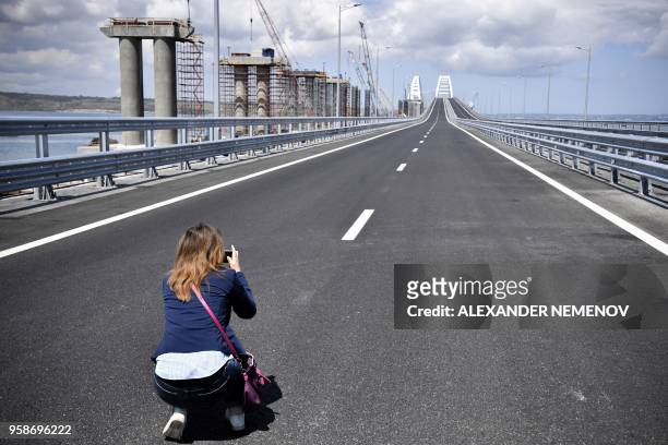 Woman takes a picture prior to the opening ceremony of the 19 km road-and-rail Crimean Bridge passing over the Kerch Straits and linking southern...