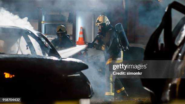firefighters using extinguisher - fire hose through car stock pictures, royalty-free photos & images