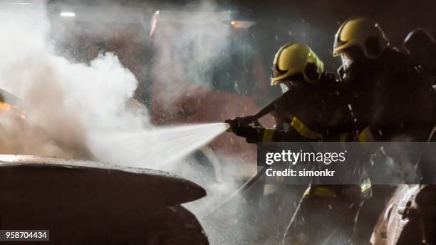 firefighters using extinguisher - fire hose through car stock pictures, royalty-free photos & images