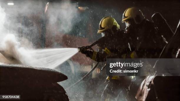 firefighters using extinguisher - fire hose through car stock pictures, royalty-free photos & images