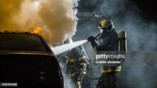 firefighters using extinguisher - fire hose through car stock pictures, royalty-free photos & images