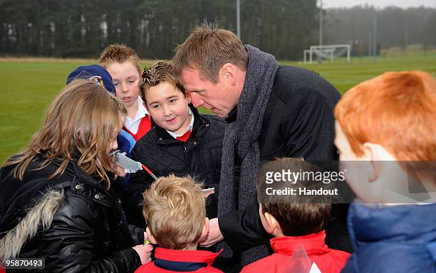 In this handout image supplied by The FA, Stuart Pearce signs autographs for children from Allsaints Primary School Rangemoore during a Media Day at...