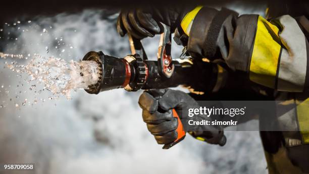 firefighter using extinguisher - firehoses stock pictures, royalty-free photos & images