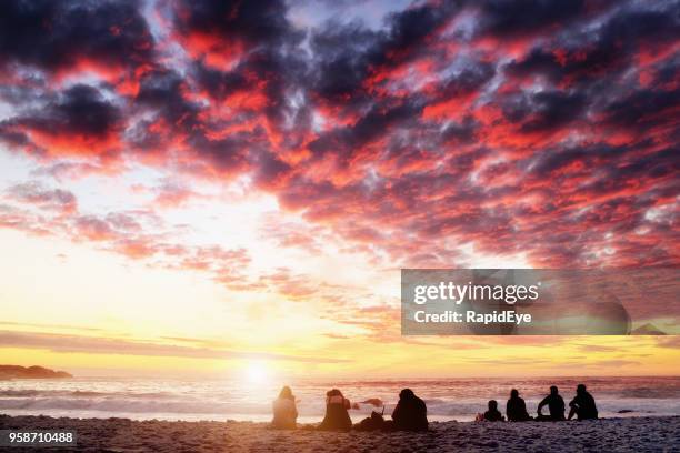 personas siluetas ver una hermosa puesta de sol sobre el mar - sun sun sea sand cloud night fotografías e imágenes de stock