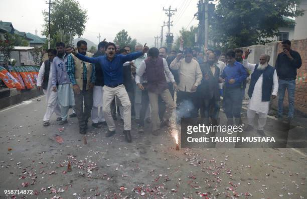 Workers from the ruling Bhartiya Janta Party light fire crackers and dance outside the BJP office in Srinagar, after poll results in the Karnataka...