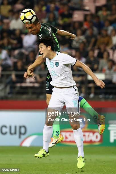 Kim Shin-Wook of Jeonbuk Hyundai Motors outjumps Yoo Jun-Su of Buriram United during the AFC Champions League Round of 16 second leg match between...