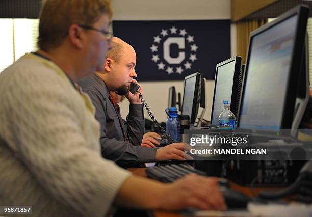 Members of the Consular Affairs Taskforce on Haiti work in an operations center at the State Department January 19, 2010 in Washington, DC. The...