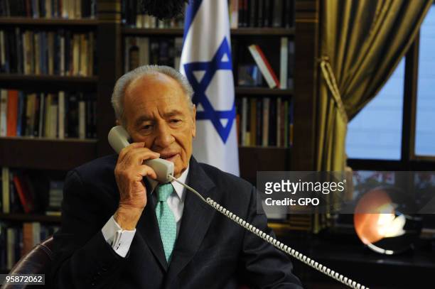In this handout image supplied by the Israeli Government Press Office , President Shimon Peres speaks on the phone to the Israeli aid team currently...
