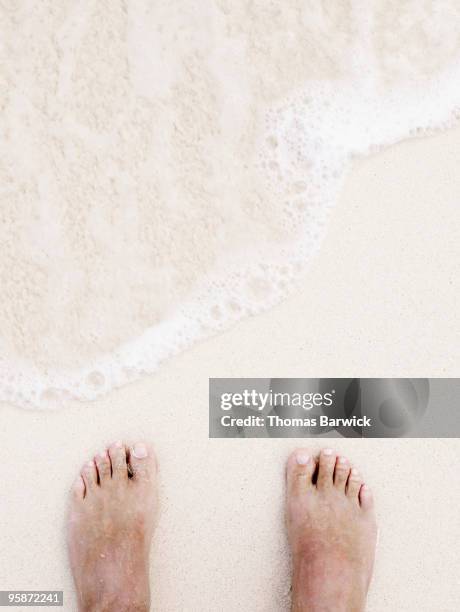 feet in sand near at waters edge overhead view - testing the water stock pictures, royalty-free photos & images