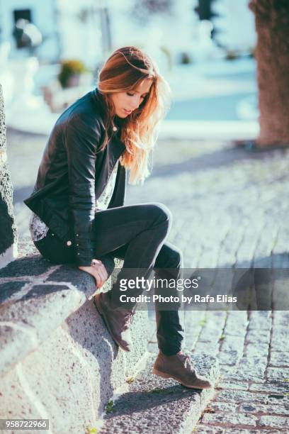 stylish young woman sitting on cement bench - suede shoe stock pictures, royalty-free photos & images