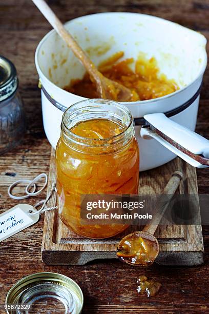 jar of marmalade on table with pan - marmalade stock pictures, royalty-free photos & images