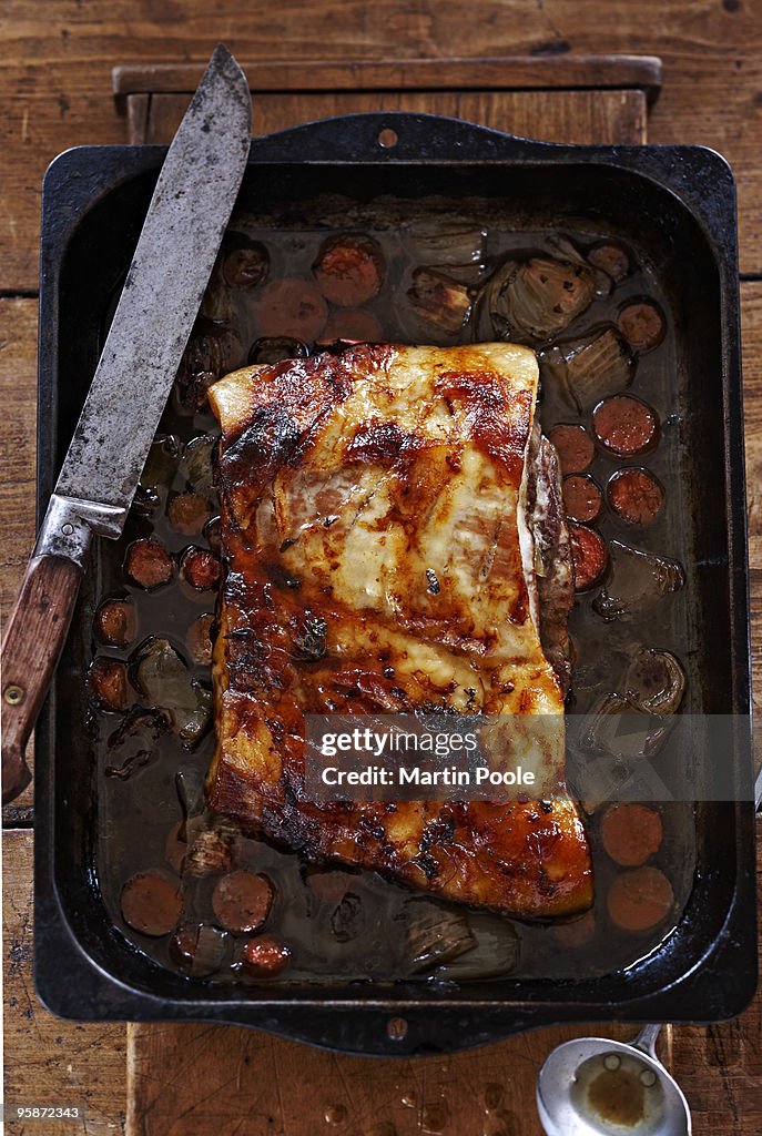 Pork belly in roasting pan with veg