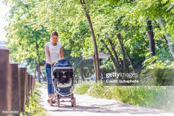 madre hija en stroller empujando - pushchair fotografías e imágenes de stock