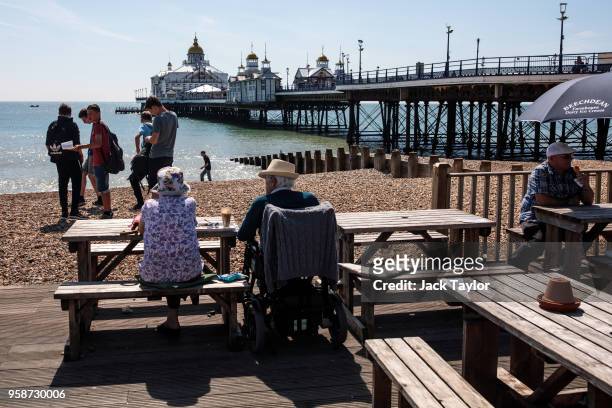 People gather along the beach in front of Eastbourne Pier on May 15, 2018 in Eastbourne, England. Britain enjoys warm and sunny weather today with...
