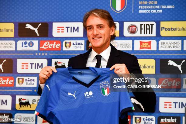 Italy's national football team newly appointed head coach, Roberto Mancini holds Italy's jersey during a press conference on May 15, 2018 at the...
