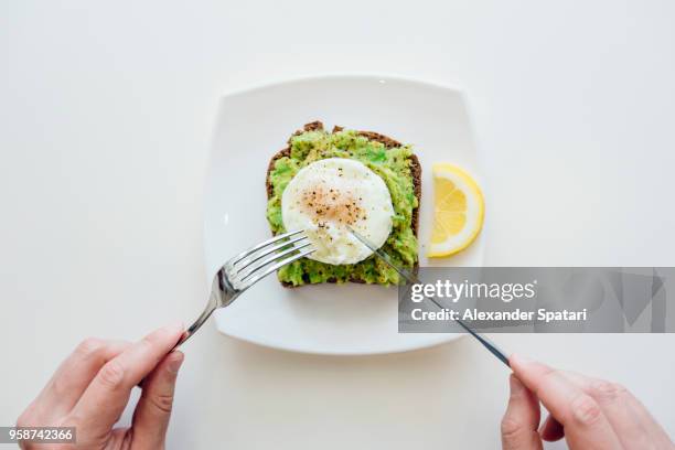 eating breakfast with avocado toast and egg from personal perspective point of view - avocado slices stock pictures, royalty-free photos & images