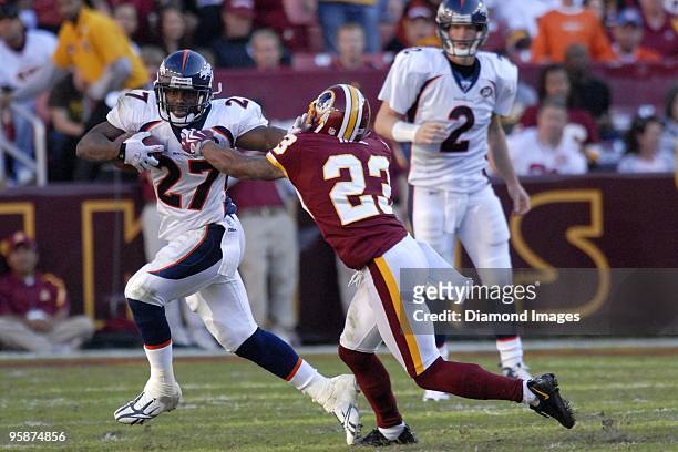 Runningback Knowshon Moreno slips by defensive back DeAngelo Hall of the Washington Redskins during a game on November 15, 2009 at Fedex Field in...