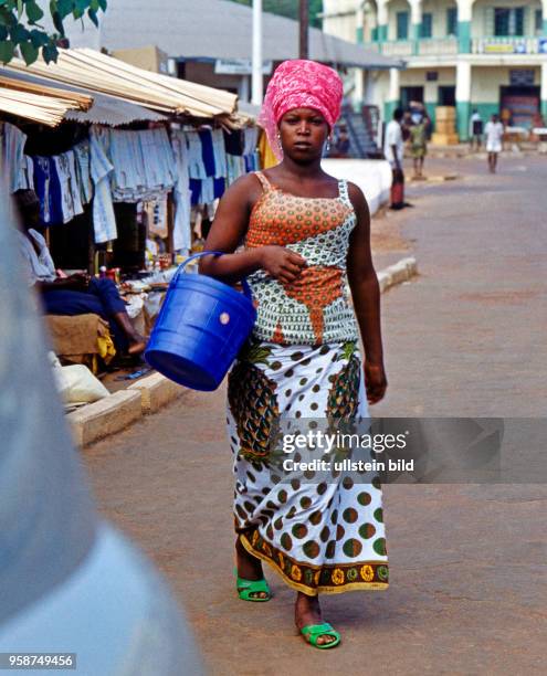 Junge Kreolin in farbenfreudigem afrikanischen Gewand auf einem Marktbummel in Freetown, der Hauptstadt Sierra Leones