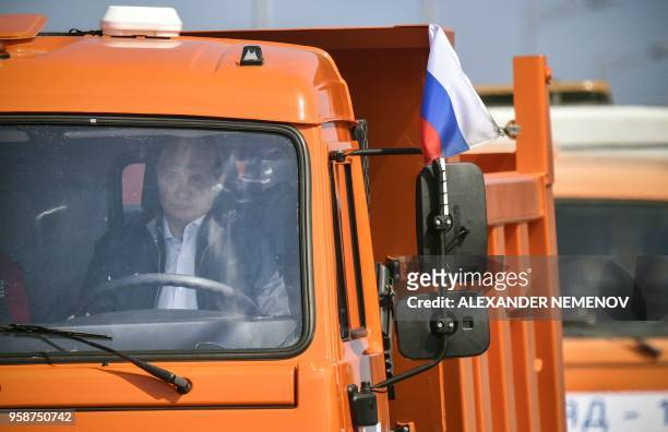 Russian President Vladimir Putin drives a construction truck across the new 19 kilometres road-and-rail Crimean Bridge over the Kerch Strait linking...