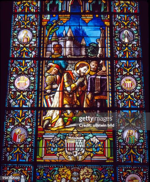 Farbiges Kirchenfenster in der Pfarrkirche des Heiligen Cornelius, Schutzpatron der Haustiere, ein kuenstlerisches Kleinod, erzaehlt Episoden der...