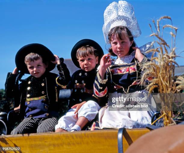 Kinder auf geschmueckter Kutsche und in traditioneller bretonischer Tracht, die in der Landschaft Finistere nur noch zu festlichen Anlaessen, wie...