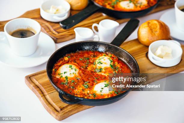 breakfast with shakshuka with tomato sauce and eggs and coffee, side view - slätpersilja bildbanksfoton och bilder