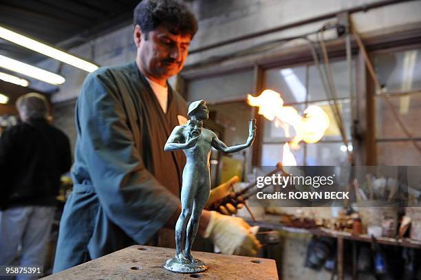 Artisan Ricardo Godinez works on an "Actor" statuette at the American Fine Arts Foundry in Burbank, California, January 19, 2010. The statuettes will...