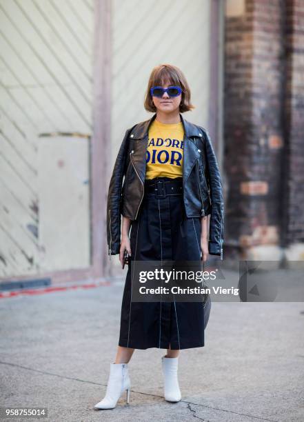 Guest wearing yellow j'adore Dior tshirt blue sunglasses, leather jacket during Mercedes-Benz Fashion Week Resort 19 Collections at Carriageworks on...