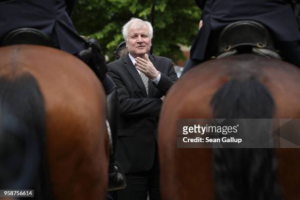 German Interior Minister Horst Seehofer chats with mounted police officers during a visit to the German Federal Police headquarters on May 15, 2018...