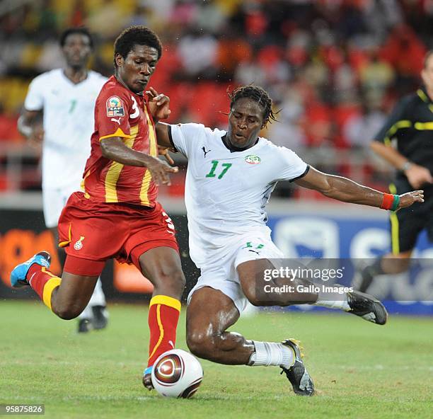 Asamoah Gyan of Ghana and Paul Koulibaly of Burkina Faso vie for the ball during the Africa Cup of Nations Group B match between Burkina Faso and...