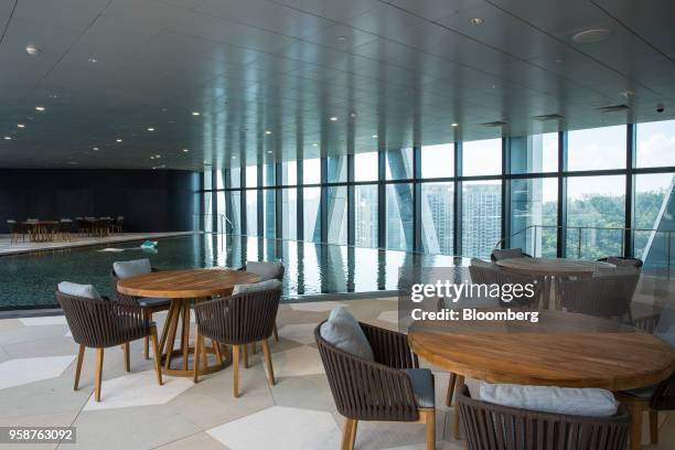 Tables and chairs stand by the swimming pool on level 40 at the Morpheus hotel, developed by Melco Resorts & Entertainment Ltd., during a media tour...