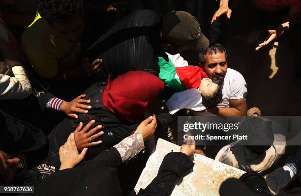 The body of eight-month-old Leila Anwar Ghandoor, who died in hospital on Tuesday morning from tear gas inhalation, is placed into a grave on May 15,...