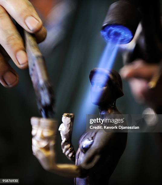Worker applies the green-black patina to an "The Actor" statuette at the American Fine Arts Foundry on January 19, 2010 in Burbank, California. The...