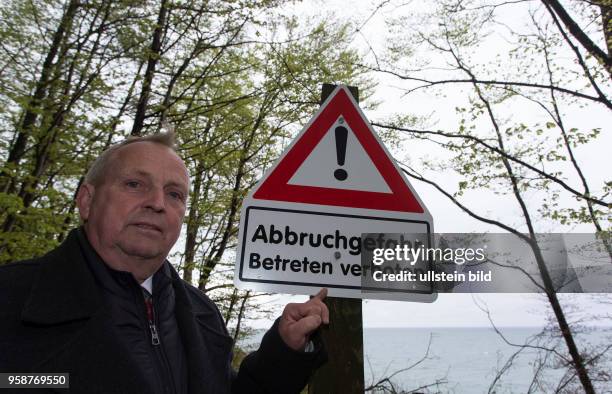 Der Landwirtschaftsminister Mecklenburg-Vorpommerns Till Backhaus steht an einem Warnschild "Abbruchgefahr - Betreten verboten"an der Kreidekueste...